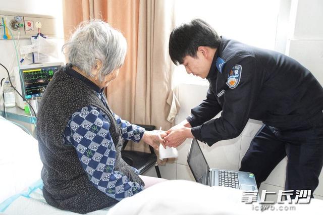 辅警在医院为市民采集指纹办身份证。