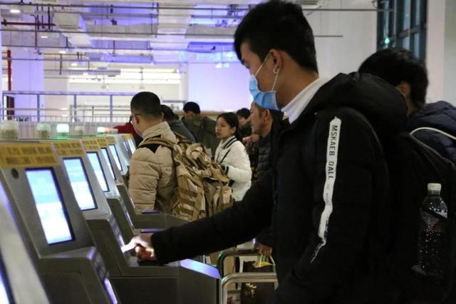 1月26日,广西柳州市火车站,乘车的民众持二代身份证和车票通过人...